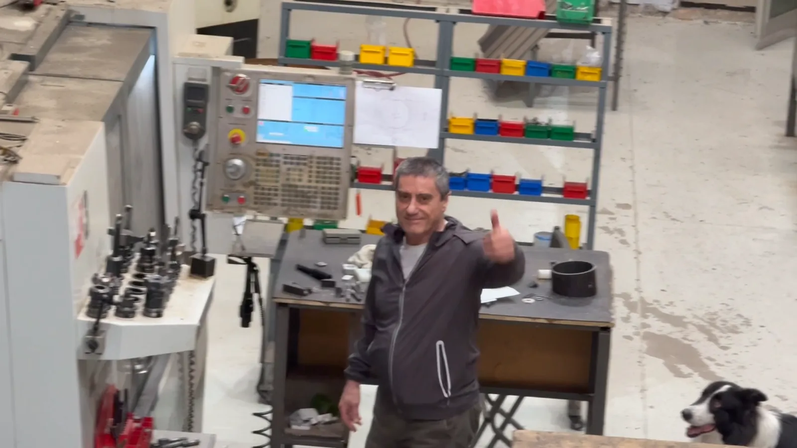 The machinist at a Haas gives a thumbs up to the office window